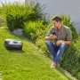 Gardena smart Sileno life Mähroboter mit Gateway und Mann mit Smartphone im Garten.