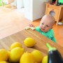 Baby am Tisch mit Abus Eckenschutz Jannic. Kindersicherung für Möbel.
