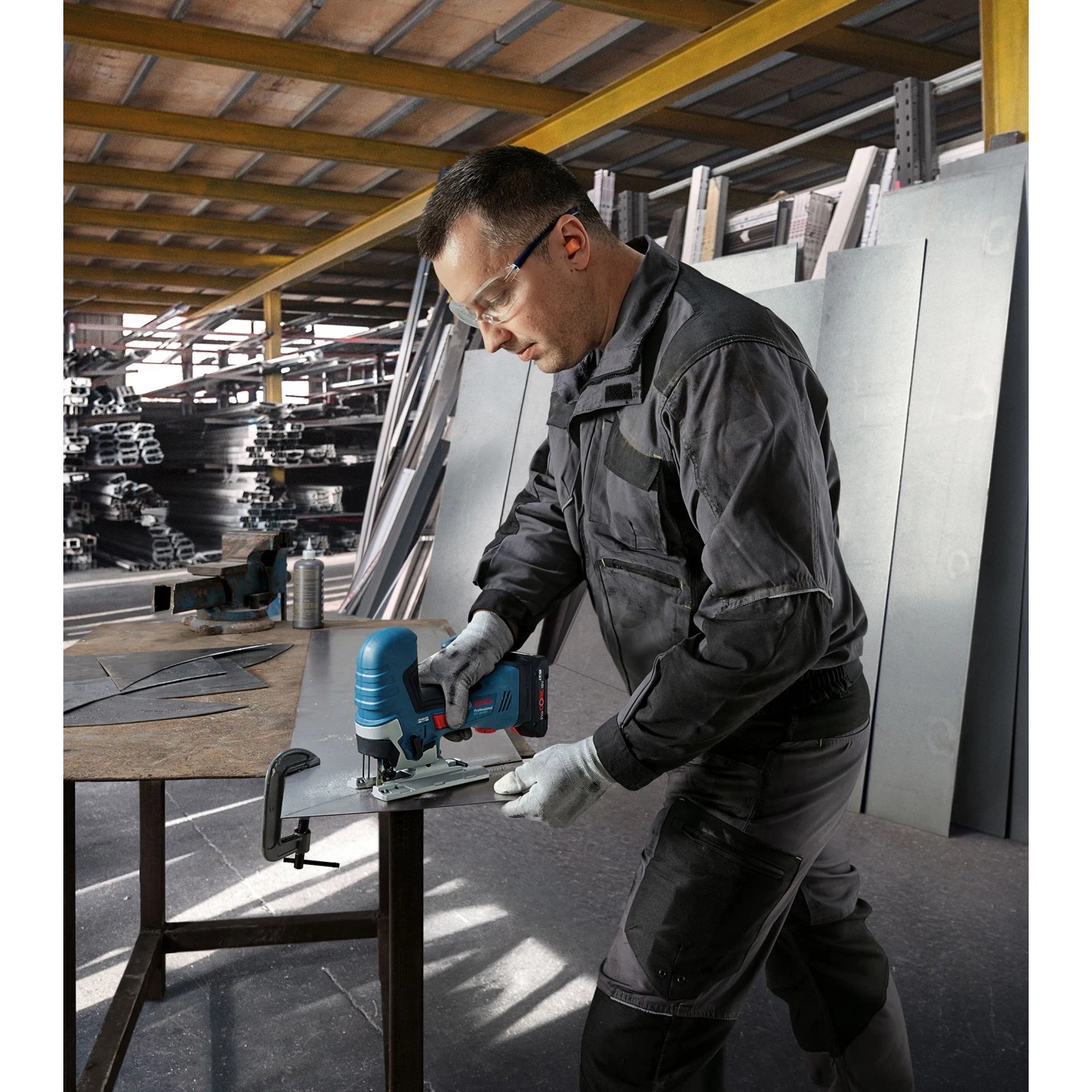 Anwender sägt mit Bosch Akku-Stichsäge GST 18V-125 ein Blech. Akkugerät aus dem Bosch Professional Kit.
