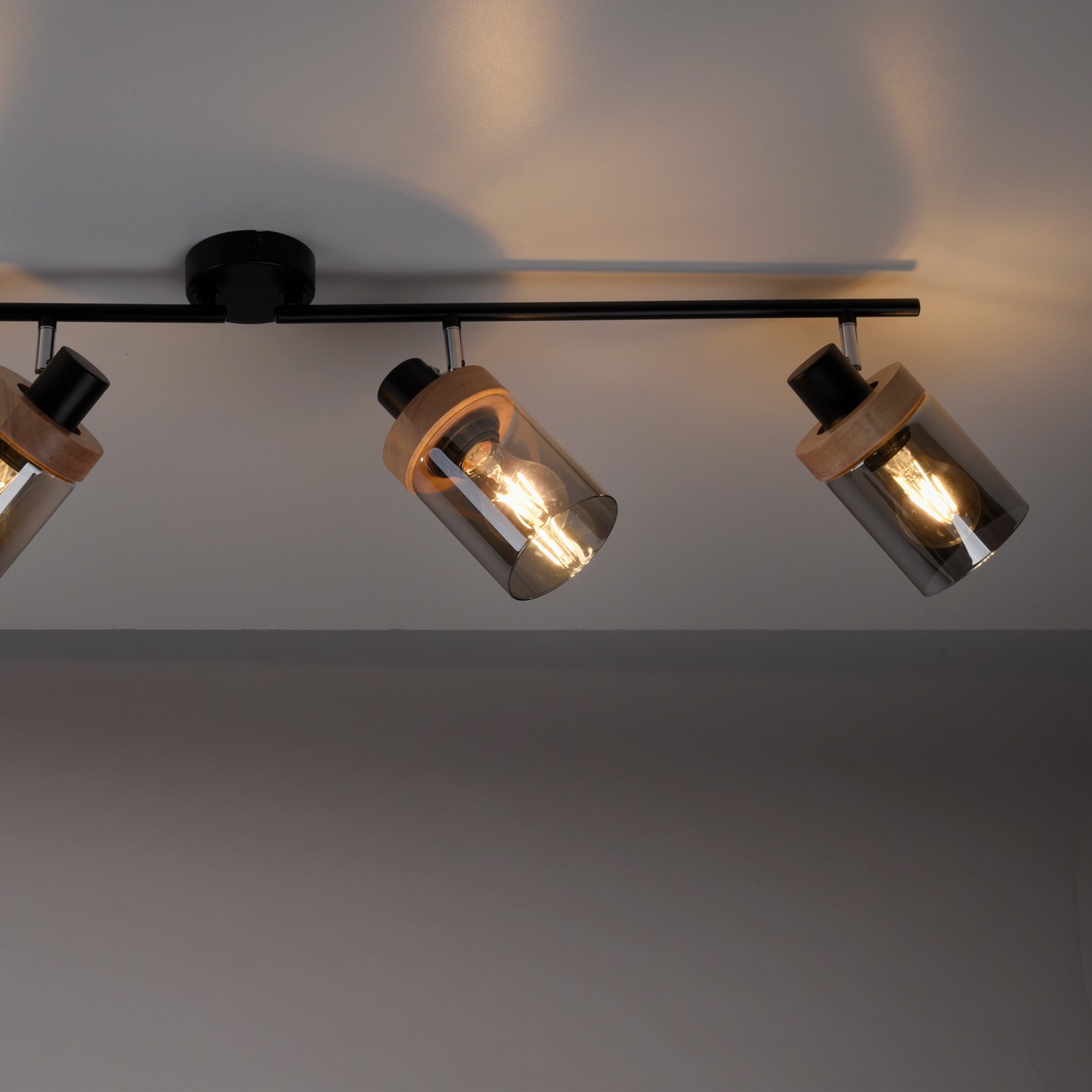 Schwarze 4-flammige Wand- und Deckenleuchte Pasqual mit Rauchglas-Schirmen und Holzdetails.