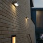 Mehrere Lutec Brick LED-Solar-Wandleuchten aus Edelstahl an einer Backsteinwand.