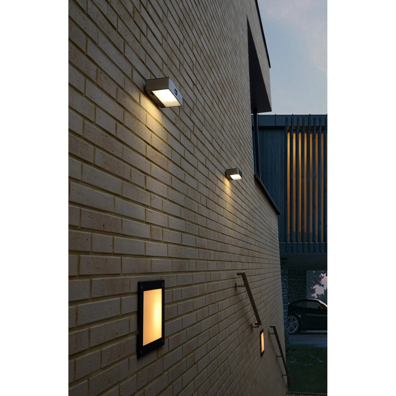 Mehrere Lutec Brick LED-Solar-Wandleuchten aus Edelstahl an einer Backsteinwand.