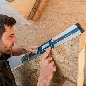 Handwerker misst Neigung mit digitalem Bosch Professional Neigungsmesser GIM 60 cm.