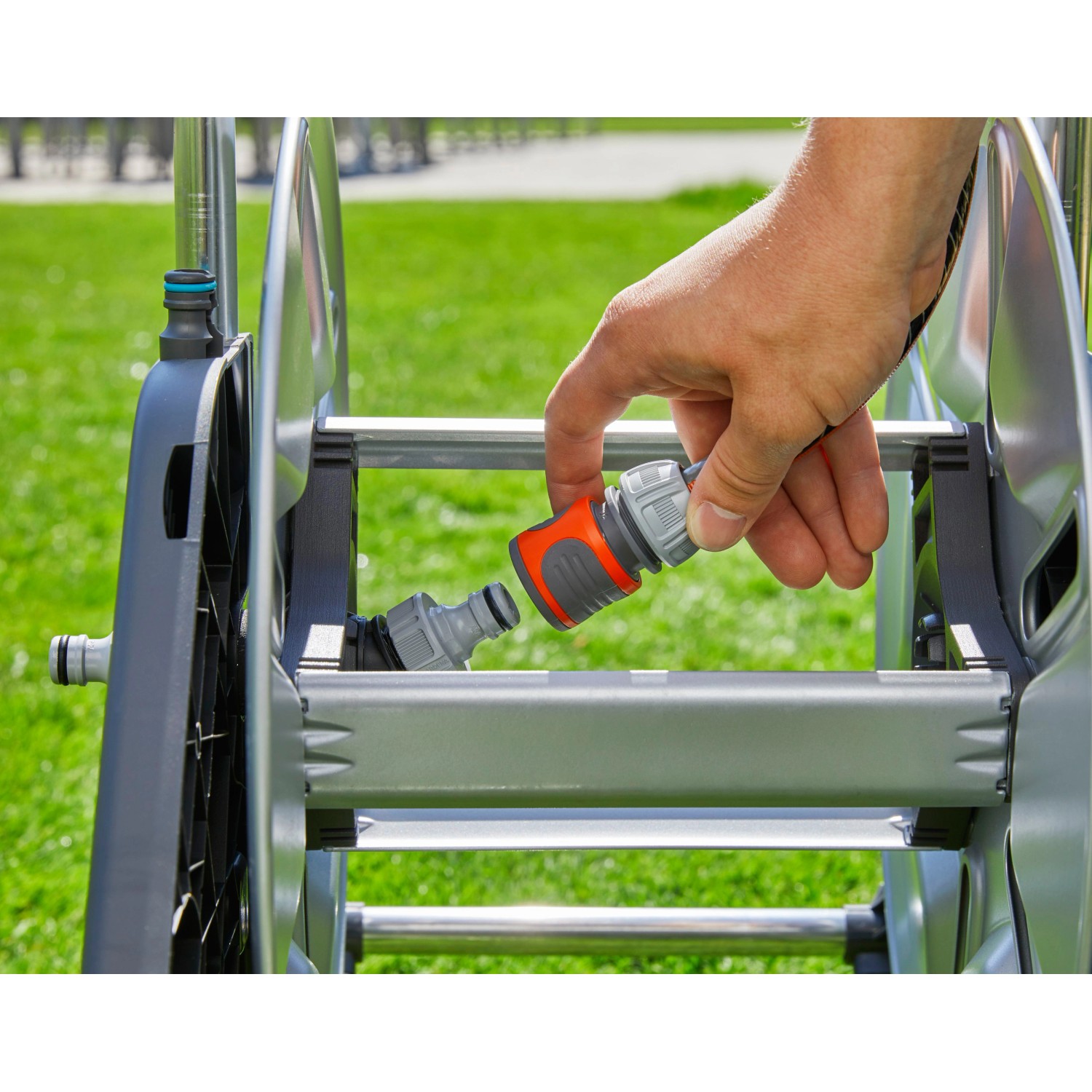 Gardena CleverRoll M Metall Schlauchwagen: Hand verbindet Schlauchstück mit Wagen.