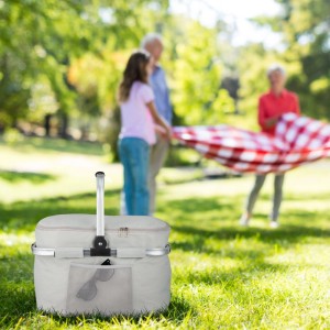 Hellgrauer, isolierter Einkaufskorb mit Alurahmen, faltbar, mit Picknick-Szene im Hintergrund.