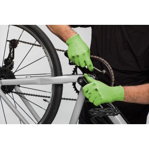 Mann repariert Fahrrad mit grünen Vileda Nitril Einweghandschuhen (S/M).