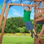 Junge hangelt sich auf dem Spielturm Northbrook an Affenstangen entlang.