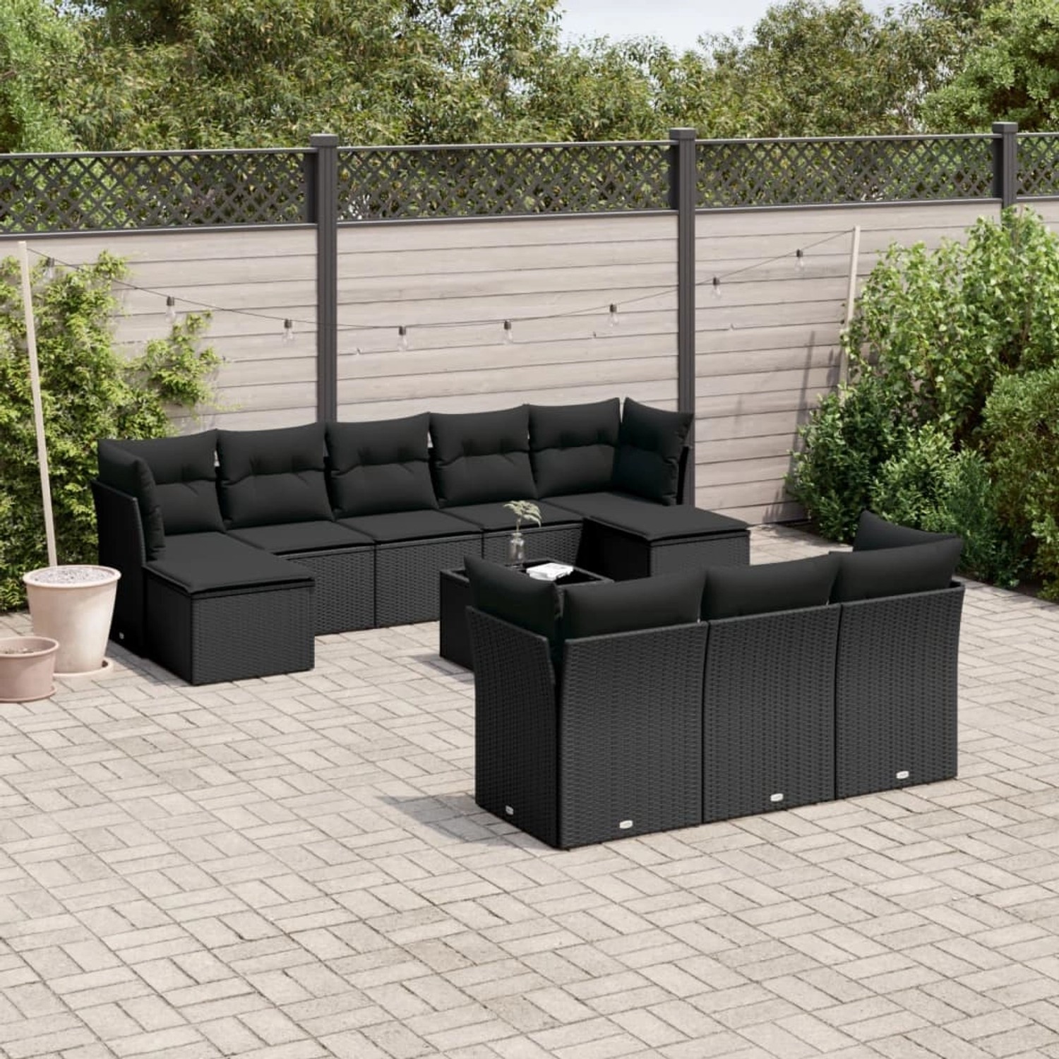 Schwarze 11-tlg. vidaXL Garten-Sofagarnitur aus Poly Rattan mit Kissen und Tisch auf einer Terrasse.