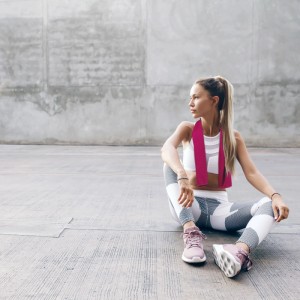 Frau mit schwarzem Relaxdays Kühlhandtuch (2er Pack) um den Hals. Kühltuch für Sport.