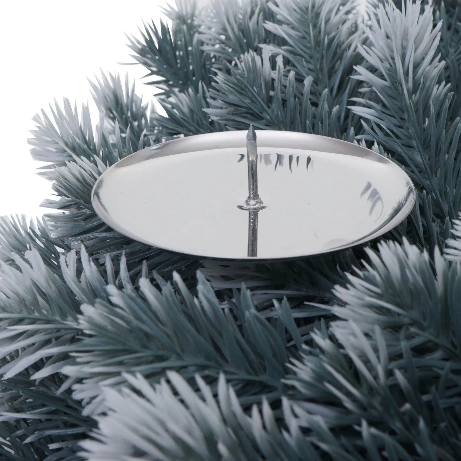 Nahaufnahme eines silbernen Kerzenhalters auf künstlichen, schneebedeckten Tannenzweigen des Weihnachtskranzes.