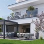 Dunkelgraue Biohort Pergola als Terrassenüberdachung mit Gartenmöbeln vor modernem Haus.