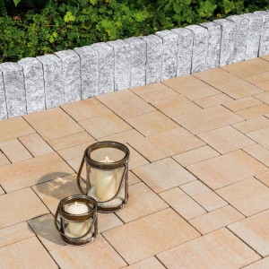 Diephaus Mauerstein Maximo Nola Granit als Gartenmauer und Bodenbelag mit Deko-Laternen.