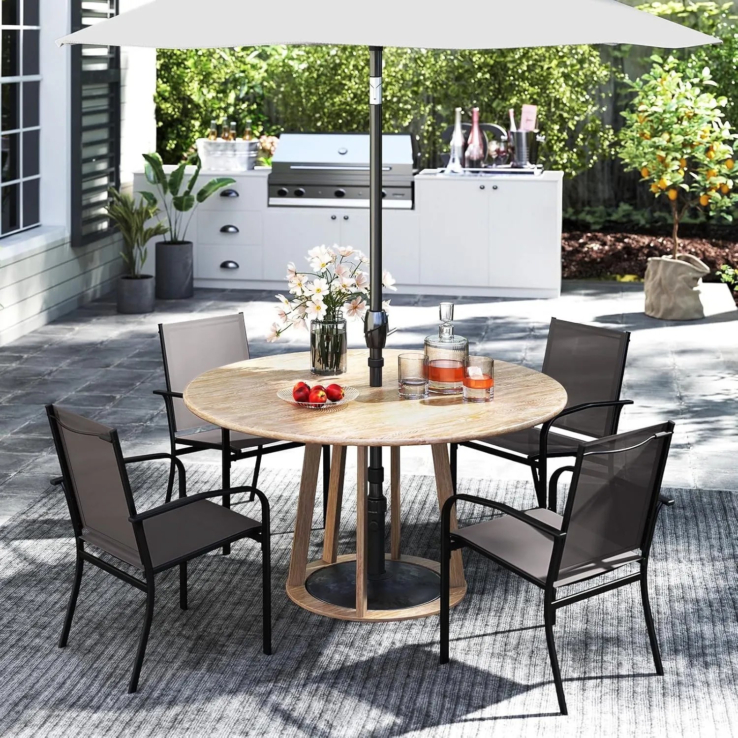 Zwei graue stapelbare Gartenstühle aus Textilene mit schwarzem Metallrahmen auf der Terrasse.