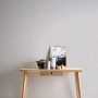 Graue Uni-Tapete von PROFHOME (377022-GU) an einer Wand, kombiniert mit einem hellen Holztisch.
