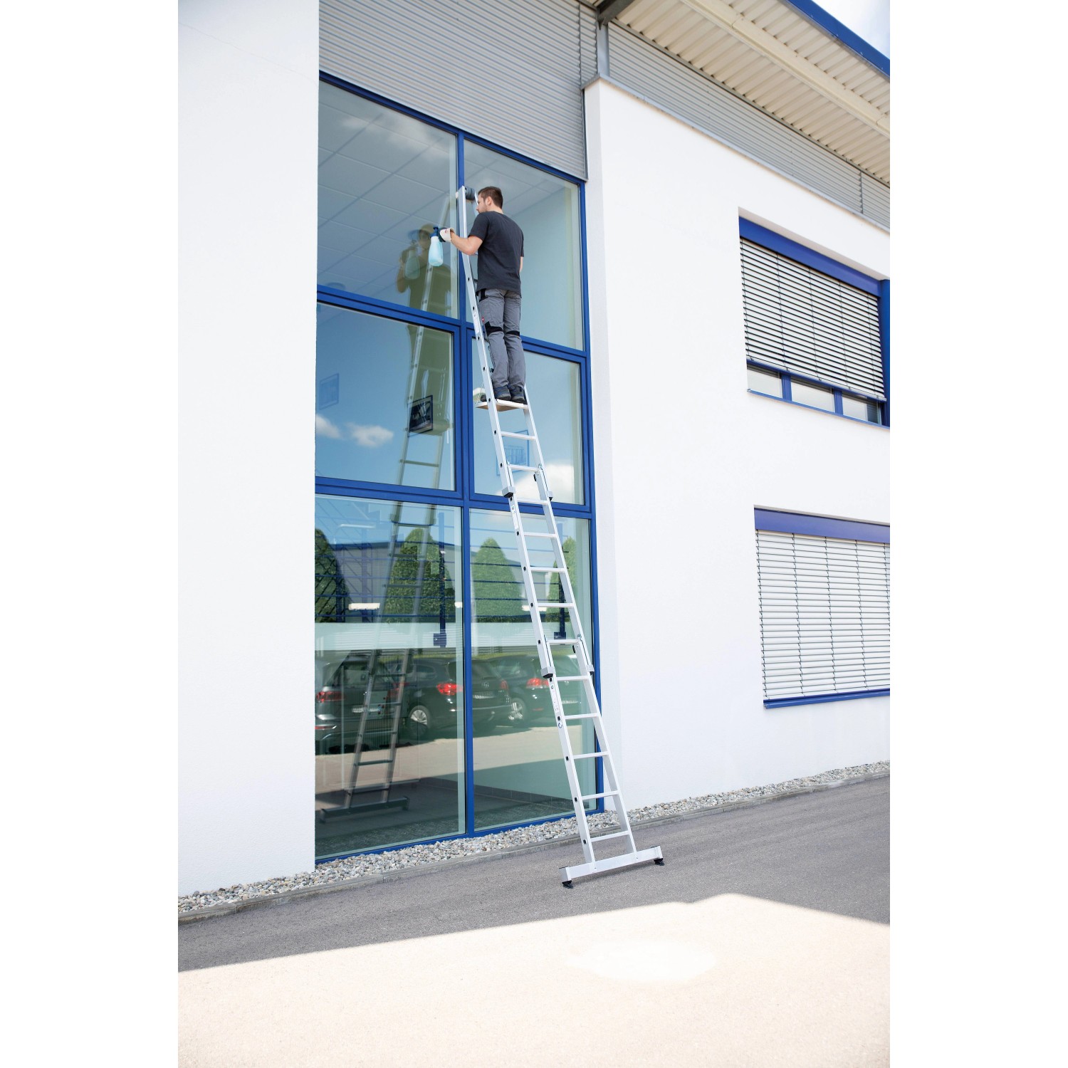 PROREGAL Sprossen-Glasreinigerleiter mit Traverse im Einsatz beim Fensterputzen.