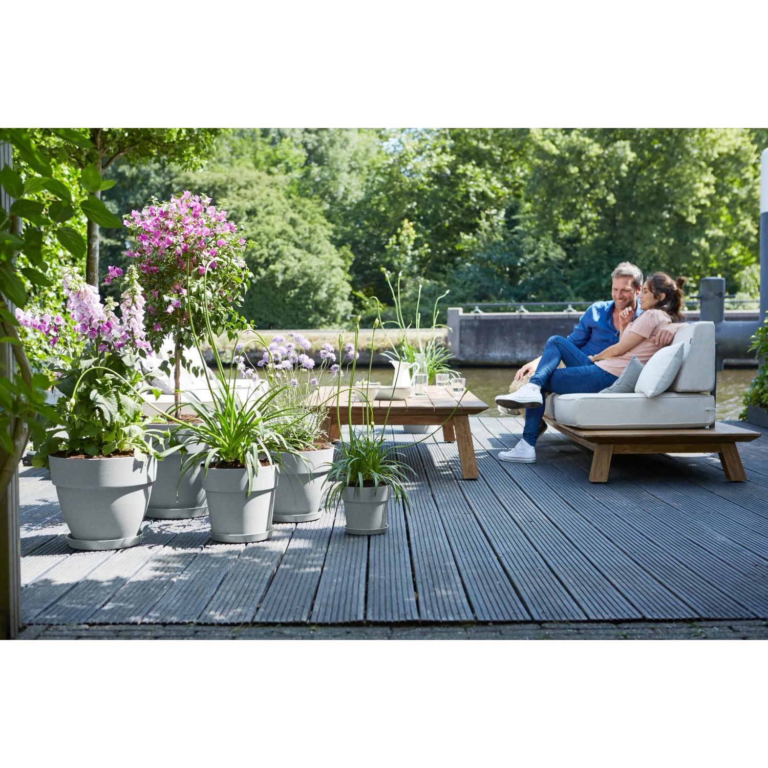 Elho Vibia Campana Blumentöpfe in Living Beton auf einer Terrasse mit Paar.