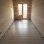 Verlegtes Belvit Fußbodenheizung Set 45m² Trockenbau mit Metallverbundrohr im Raum.