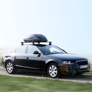 Schwarze Auto-Dachbox G3 220 l auf einem Auto montiert. Ideal für Reise & Transport.
