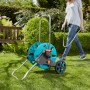 Gardena CleverRoll M Schlauchwagen im Garten mit Frau beim Bewässern.