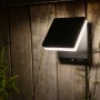 Moderne, eckige Lutec Solar-LED-Außenleuchte Moze in Schwarz Matt an einer Holzwand.