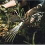 Fiskars Xact Hand-Fächerbesen mit 7 Zinken im Einsatz im Garten.