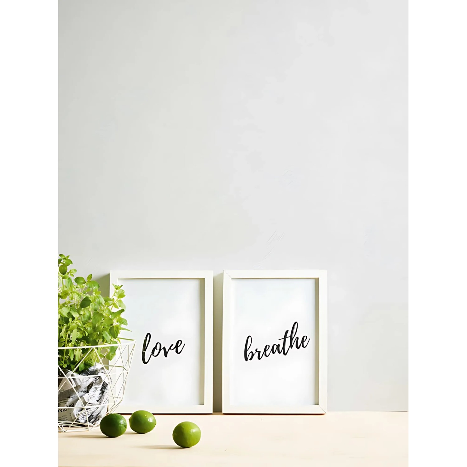 Uni Tapete in Weiß mit zwei Bilderrahmen mit den Schriftzügen 'Love' und 'Breathe'.