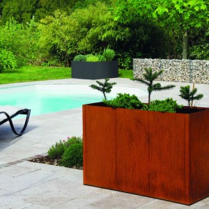 Rostbraunes bellissa PANNELLO Corten Hochbeet, 50 cm hoch, mit Pflanzen im Garten am Pool. Erweiterungs-Segmente.