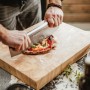 Enders Pizzaschneider aus Edelstahl schneidet Pizza auf Holzbrett. Grillutensil für präzise Pizzastücke.