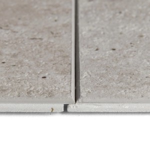 Nahaufnahme von zwei grauen Grosfillex SPC Wandpaneelen mit Betonoptik und Nut-Feder-Verbindung.