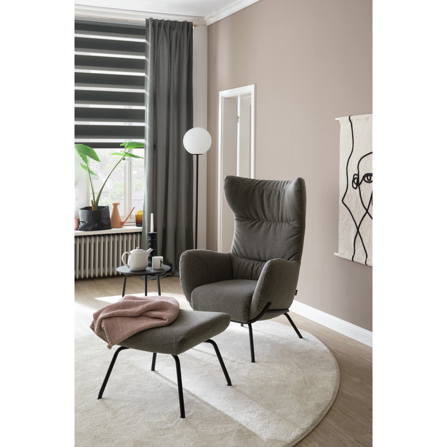 Graues Schöner Wohnen Doppelrollo Tilda, 120x150cm, im Wohnraum mit Sessel und Tageslicht.