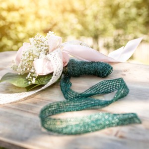 Windhager Baumanbinder, 50m Rolle, dunkelgrün, neben Blumenstrauß auf Holztisch.