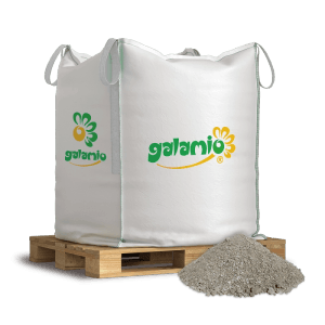 Galamio Brechsand 500kg im weißen BigBag auf Holzpalette, daneben ein Haufen Sand. Für Pflasterbettung.