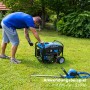Güde Stromerzeuger GSE 3701 RS im Einsatz mit Heckenschere im Garten.