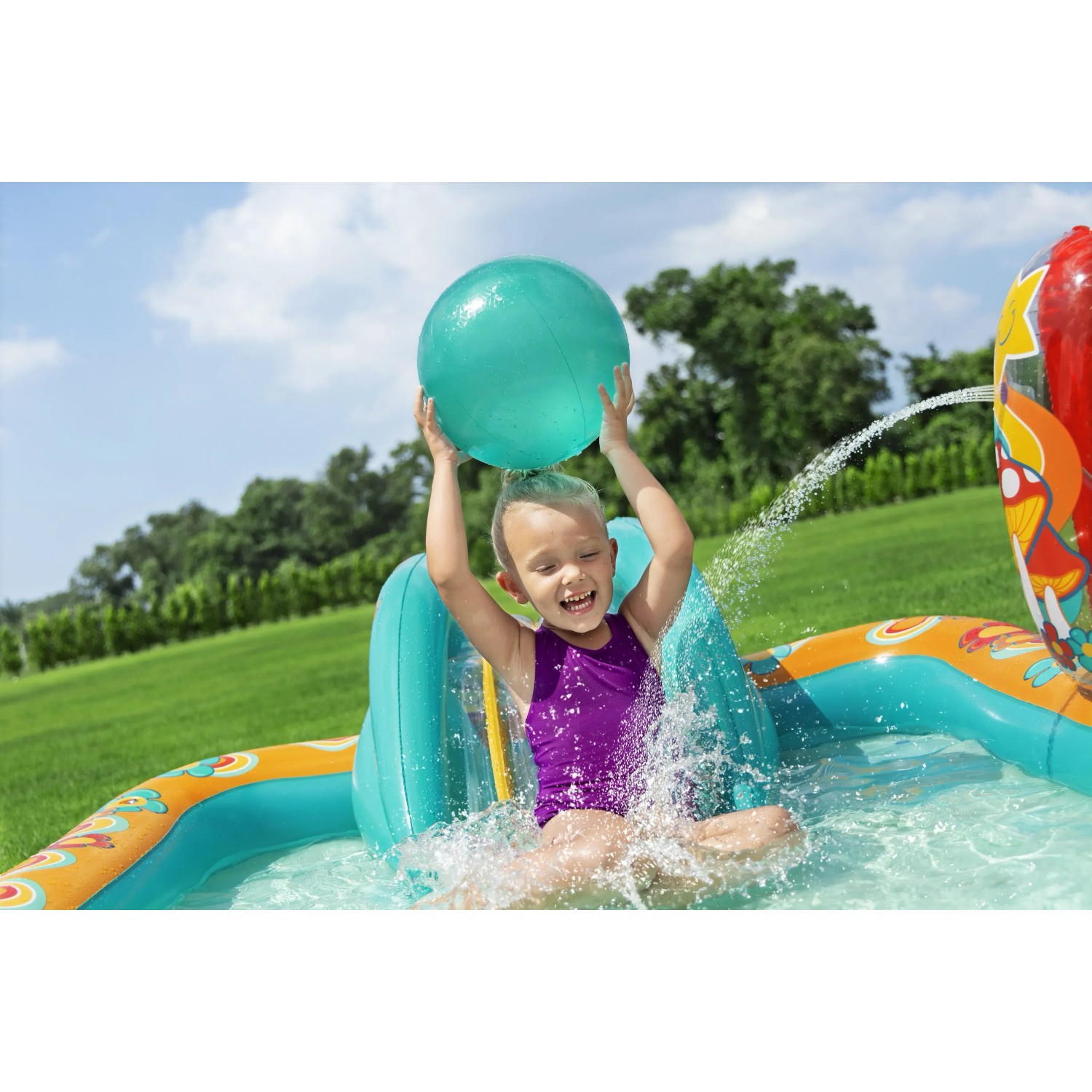 Kind spielt mit Ball im Bestway Wasserspielcenter Retro Welt mit Rutsche und Sprinkler.