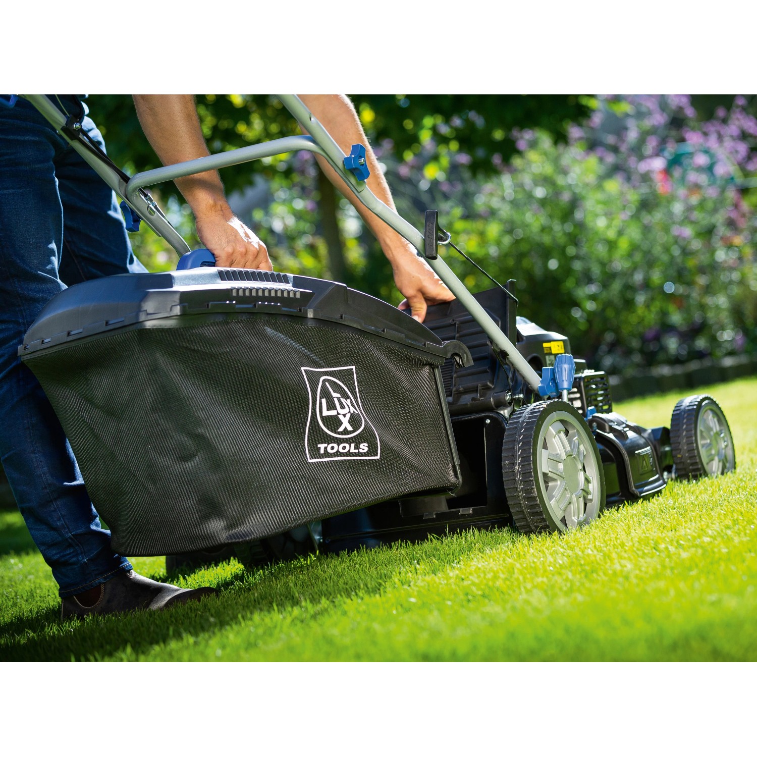 LUX-TOOLS Benzin-Rasenmäher B-RM-51-A B in Aktion mit Grasfangkorb auf Rasen.