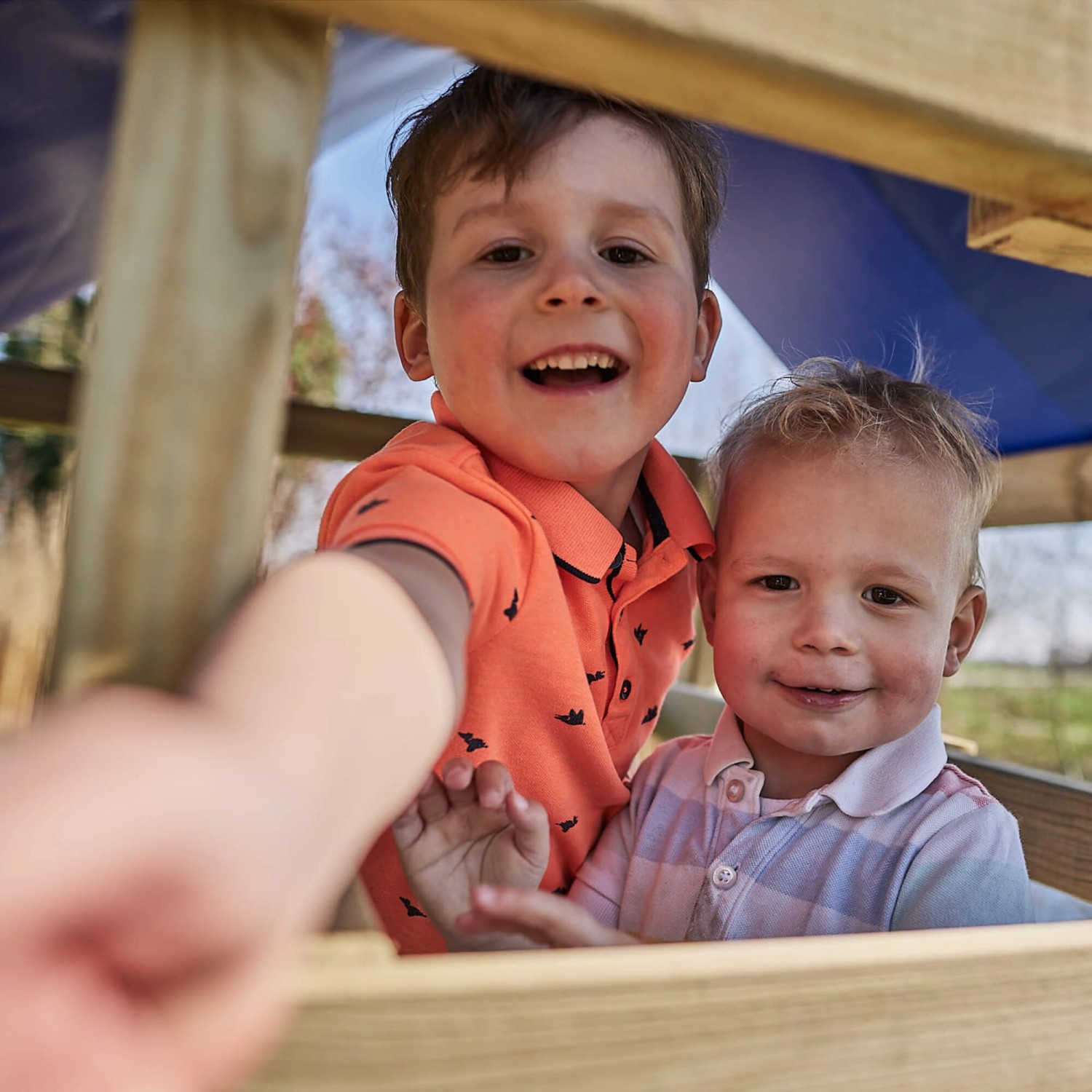 Fröhliche Kinder im pastellgrünen Wickey Spielturm FarmFlyer mit Rutsche.