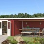 Schwedenrotes Lasita Gartenhaus St Louis mit Doppeltür und überdachtem Anbau.