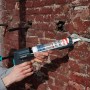 Wolfcraft Kartuschenpresse MG 600 Pro in Anwendung an einer Ziegelwand.