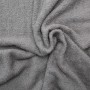 Graues, weiches Frottee Handtuch Marbella für Liegen. Detailaufnahme des flauschigen Baumwollstoffs mit Falten.