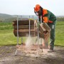Wolfcraft Sägebock FSC® im Einsatz: Mann sägt Holz mit Kettensäge. Sicherer Arbeitsbock für Brennholz.