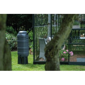 Schwarze Halls Regentonne mit Ständer (100 l) neben Gewächshaus im Garten.