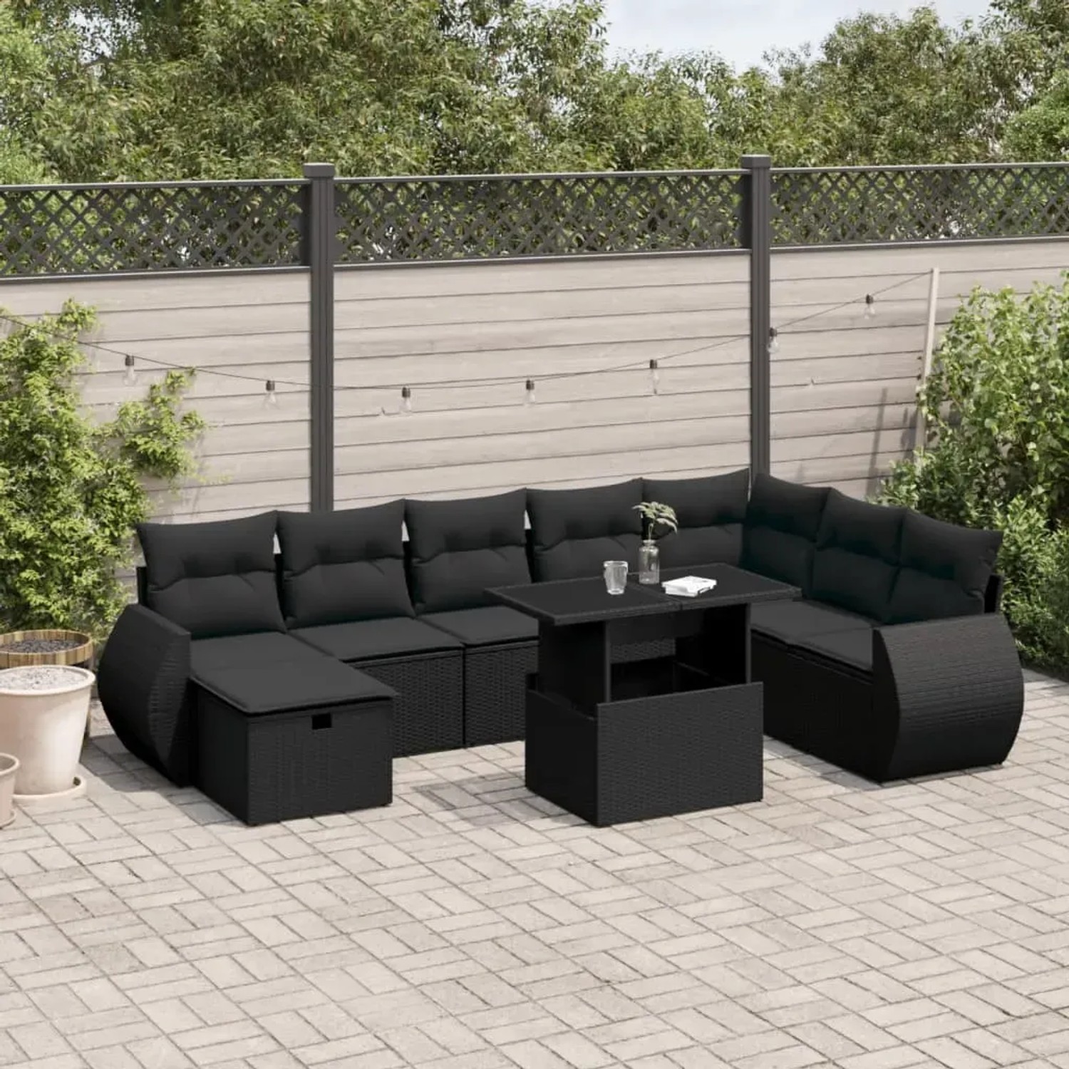 Schwarze 9-teilige Garten-Sofagarnitur aus Poly Rattan mit Tisch und Kissen.