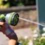 Geka Multibrause Plus 5S Grau in Aktion: Gartenspritze mit Wasserstrahl im Garten.