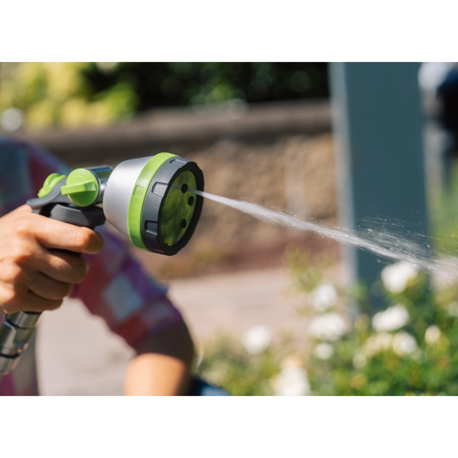 Geka Multibrause Plus 5S Grau in Aktion: Gartenspritze mit Wasserstrahl im Garten.