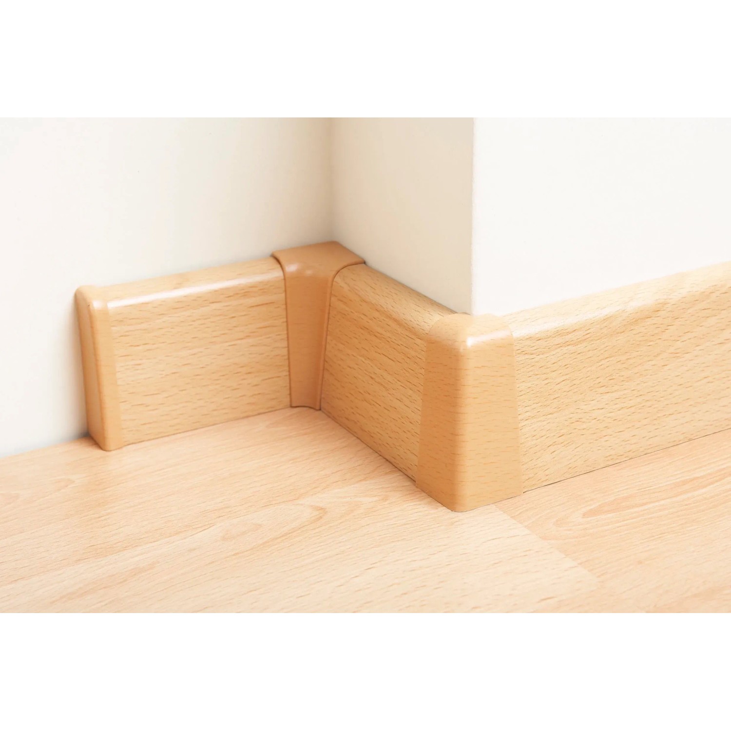 OBI Endstück Buche, 2er-Set, 60 mm x 20 mm für Sockelleisten, montiert in einer Ecke.