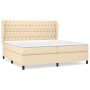 Cremefarbenes Boxspringbett 200x200 cm mit gestepptem Kopfteil und Matratze.