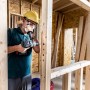 Handwerker bohrt mit Bosch Expert Flachfräsbohrer ein Loch in einen Holzrahmen.