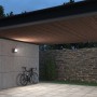 Steinel Sensor-LED-Strahler XLED One S Anthrazit an Betonwand, beleuchtet Fahrrad im Außenbereich.