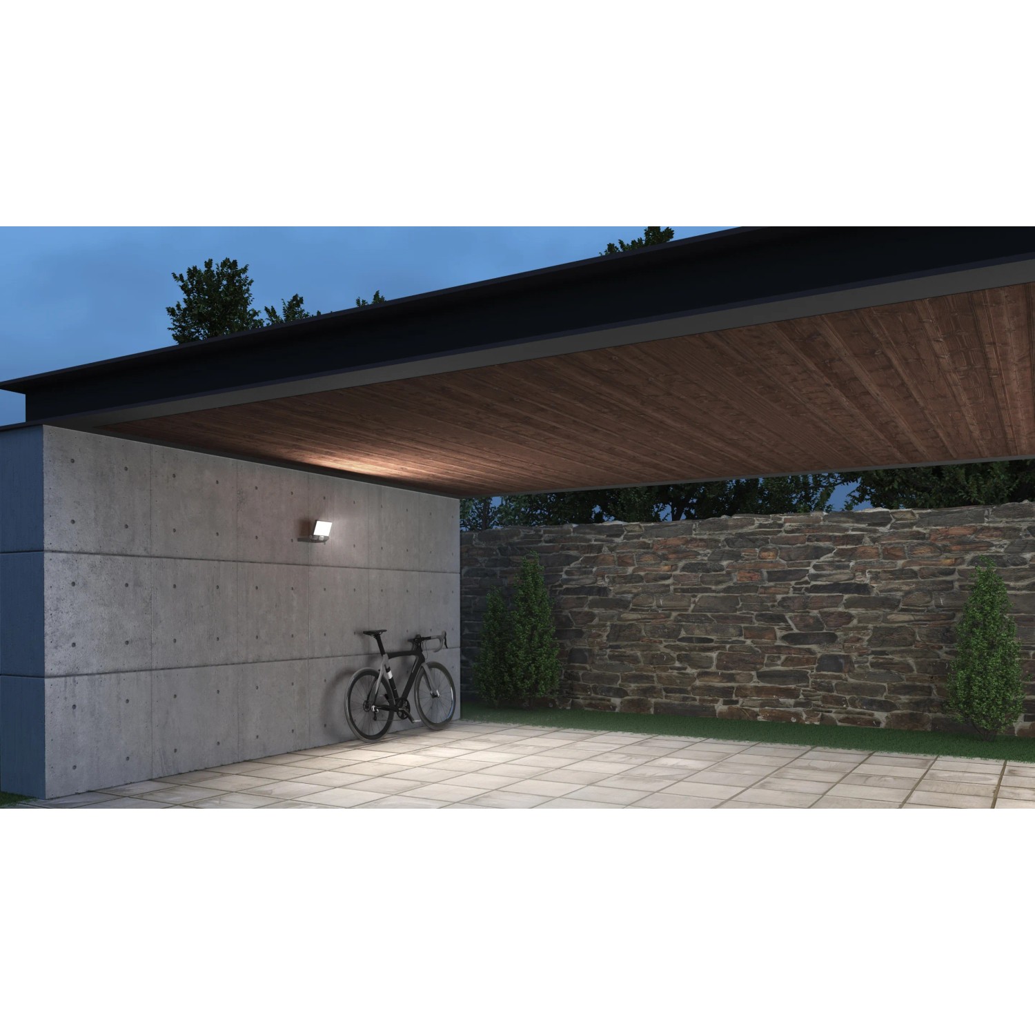 Steinel Sensor-LED-Strahler XLED One S Anthrazit an Betonwand, beleuchtet Fahrrad im Außenbereich.