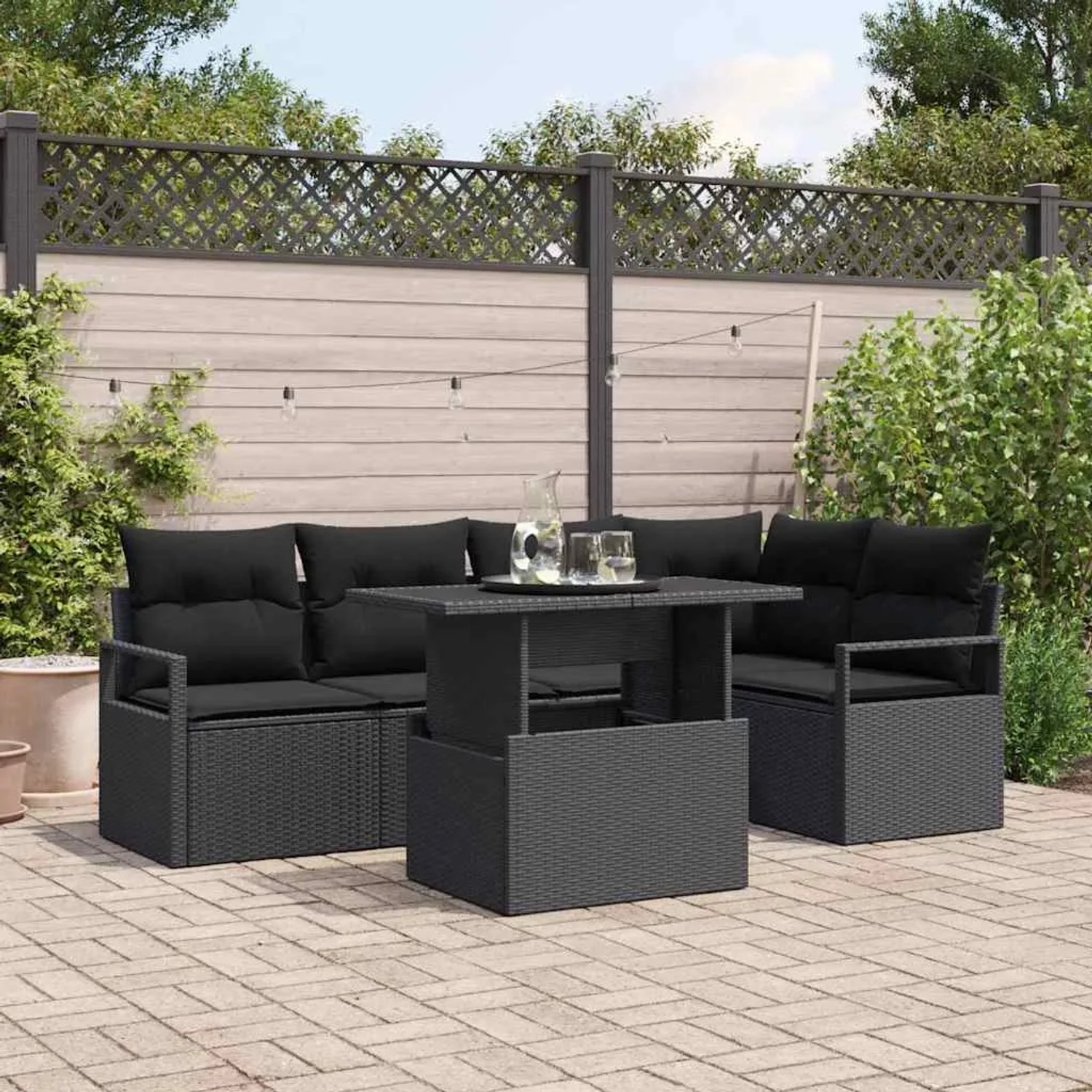 Schwarzes 6-tlg. Garten-Sofa-Set aus Poly Rattan mit Tisch und schwarzen Kissen.